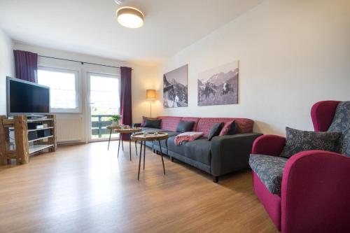 a living room with a couch and a tv at Ferienwohnungen Alpentraum - Gerstruben in Fischen