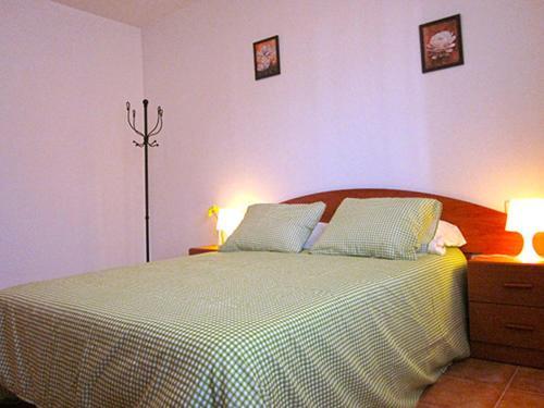 1 dormitorio con 1 cama grande y 2 lámparas en Apartamentos El Hortalán, en Mora de Rubielos