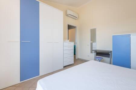 1 dormitorio con 1 cama blanca y armario azul en Nuovissimo Bilocale al Mare en Villa San Pietro