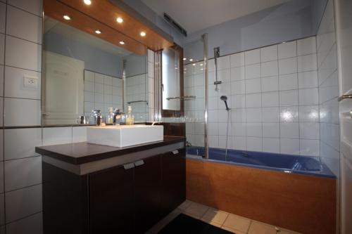 a bathroom with a sink and a tub and a mirror at Belle maison in Argonay