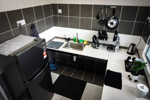 a small kitchen with a sink and a refrigerator at 80'S PARADISE in Tanah Rata