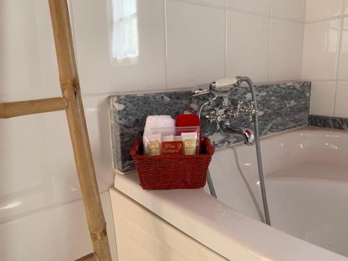 bañera con ducha y cesta en un lavabo en Vila Aurora, en Parada de Gatim