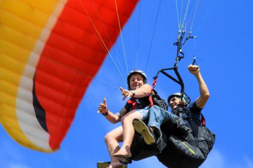 two people are riding on a parachute at Sky Island Resort in Ponta Malongane