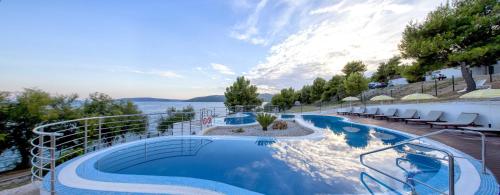 uma piscina com vista para a água em Happy Camp mobile homes in Camping Amadria Park Camping Trogir em Seget Vranjica