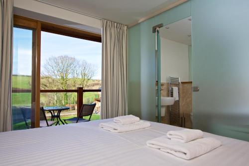 BlackawtonにあるDartmouth Green Lodgesのベッドルーム1室(ベッド1台、タオル2枚付)