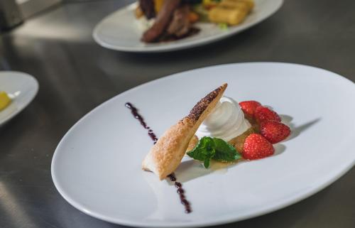 a plate with a dessert with strawberries and whipped cream at Pflegehotel Sutz-Lattrigen in Sutz-Lattrigen