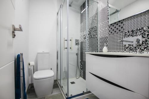 a bathroom with a toilet and a glass shower at Higuericas Costa 412 - Rooftop terrace and pool view 300 m from beach in Pilar de la Horadada