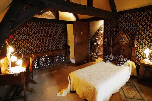 a bedroom with a bed and a table with a lamp at Auberge Du Bon Fermier in Valenciennes