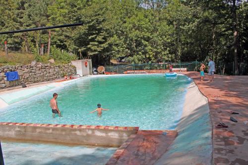 un groupe de personnes jouant dans une piscine dans l'établissement Camping le P'Tit Bonheur, à Escaro