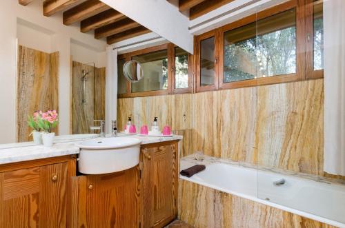 a bathroom with a tub and a sink and a bath tub at Villa Son Floriana in Son Servera