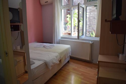 a small bedroom with a bed and a window at Sur Istanbul Hotel in Istanbul