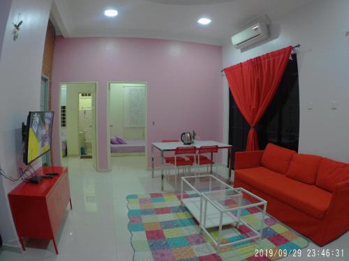 a living room with a red couch and a table at Holiday Homestay Dungun in Dungun