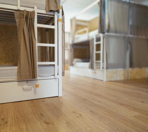 ein leeres Zimmer mit 2 Etagenbetten und Holzboden in der Unterkunft Albergue Nacama Hostel Pontevedra PEREGRINOS PILGRIMS in Pontevedra