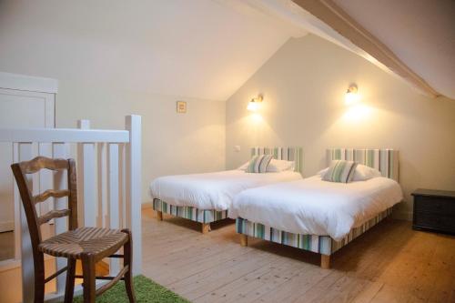 una camera da letto con due letti e una sedia di Château Pech-Celeyran a Salles-dʼAude