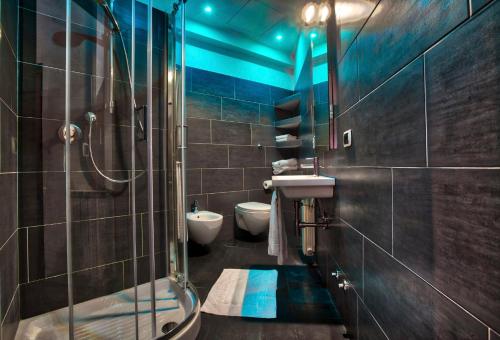 ローマにあるTourist House B&Bのバスルーム(トイレ2つ、ガラス張りのシャワー付)