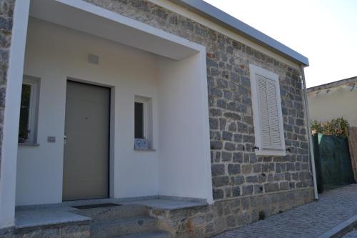 a brick building with a door and a window at Borgo Marinaro La Medusa Arbatax - camera matrimoniale con bagno privato- in Àrbatax
