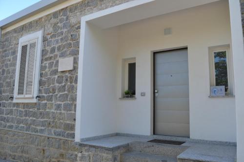 a white garage door on a brick wall at Borgo Marinaro La Medusa Arbatax - camera matrimoniale con bagno privato- in Àrbatax