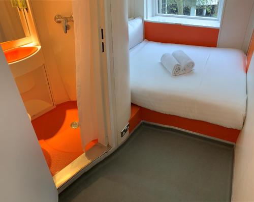 a bedroom with a bed and a window at easyHotel South Kensington in London