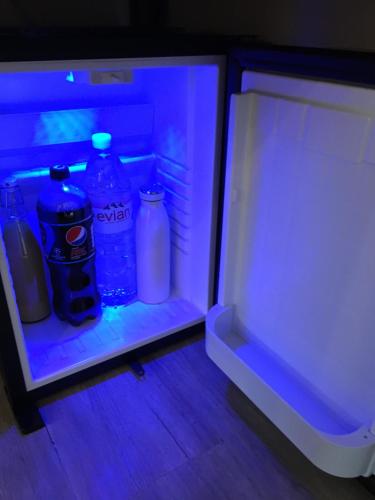 een open koelkast met flessen water en melk bij The Annexe at Asbit Lodge in Mildenhall