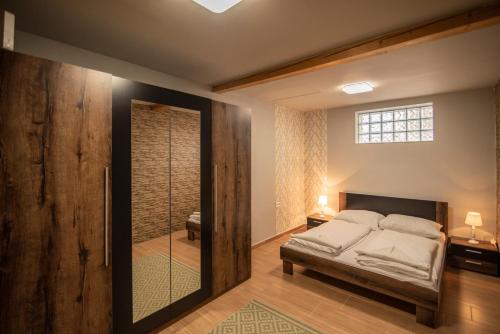 a bedroom with a bed and a sliding glass door at Zsálya Vendégház in Demjén