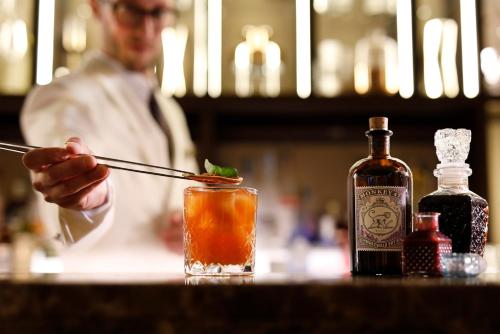 a man is stirring a drink with a pair of chopsticks at Casa Bianca Apartments in Como