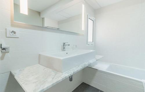 een witte badkamer met een wastafel en een bad bij Hotel LIVVO Koala Garden in Maspalomas