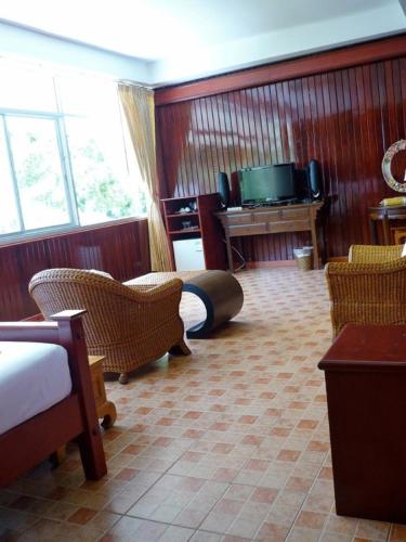 a room with a bed and chairs and a television at Rajapruek Samui Resort - SHA Plus in Lipa Noi