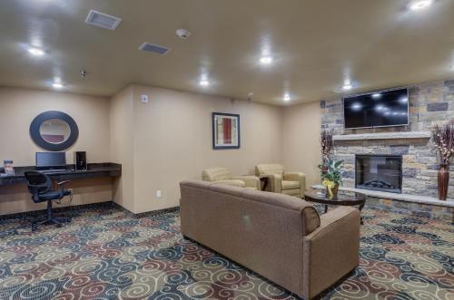 a living room with a couch and a fireplace at Cobblestone Inn & Suites-Kersey in Kersey