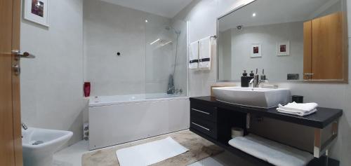 uma casa de banho com um lavatório, uma banheira e um WC. em Sweethome em Lisboa