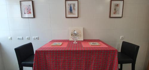 a red table with two chairs and a wine glass on it at Sweethome in Lisbon