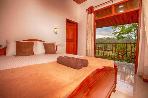 a bedroom with a bed and a large window at Ella Breeze Homestay in Ella