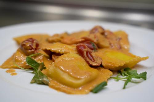 a white plate of food with nuts and sauce at Annia Park Hotel Venice Airport in Tessera