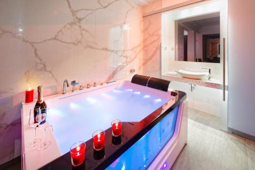 a bathroom with a tub with wine bottles and a sink at Hotel Aura Design & Garden Pool in Prague