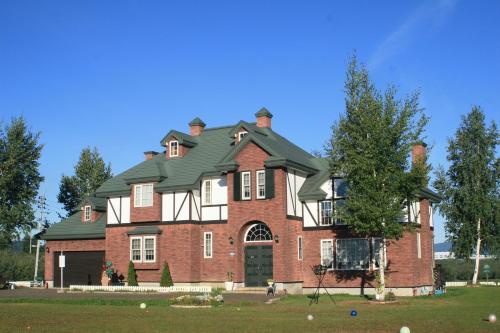 a large red brick house with a green roof at Agri In Holiday in Hirosaki