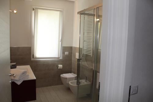 a bathroom with a toilet and a sink and a window at Residenza Sante in Lazise