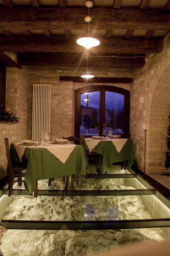 a dining room with two tables with green table cloth at Agriturismo Antico Muro in Sassoferrato