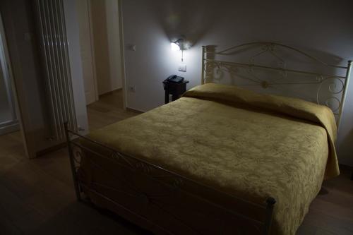a bedroom with a large bed with a yellow blanket at Agriturismo Antico Muro in Sassoferrato