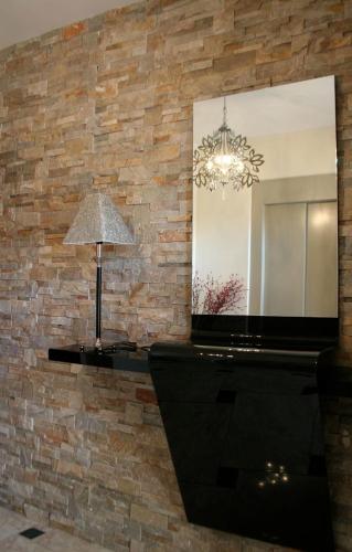a mirror on a brick wall with a lamp at Hostal Mesón Castilla in Sigüenza