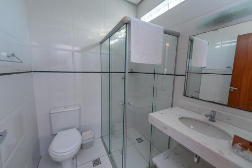 een witte badkamer met een toilet en een wastafel bij Pousada Villa da Mata in São Miguel Arcanjo