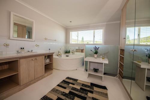 y baño con bañera, lavamanos y ducha. en Brenton Beach House, en Brenton-on-Sea