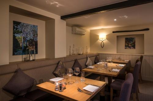 a restaurant with wooden tables and chairs with wine glasses at Number Four at Stow in Stow on the Wold