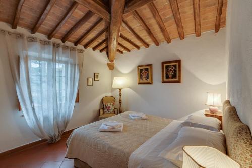 a bedroom with two beds and a large window at Casa Irene in San Gimignano