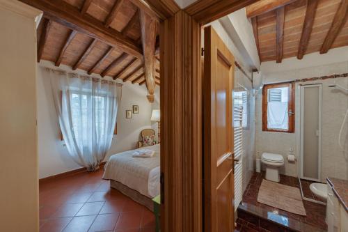 a bedroom with a bed and a bathroom with a toilet at Casa Irene in San Gimignano