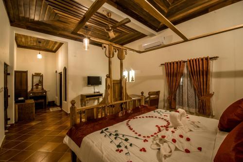 a bedroom with a large bed with a flower arrangement on it at Flamingo Boutique Hotel & Ayurvedic spa in Mararikulam