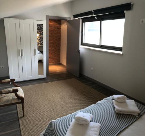 a bedroom with a bed and a window with towels on it at Casas adosadas julieta in Ribadesella