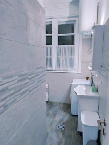 a white bathroom with a sink and a toilet at Podgorica Center in Podgorica