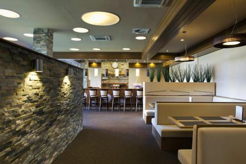 a restaurant with chairs and a brick wall at Hotel Monínec in Moninec