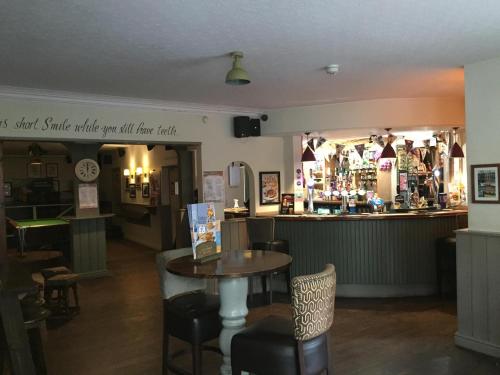 un restaurante con una mesa y un bar en The Victoria Hotel en Burnham on Sea