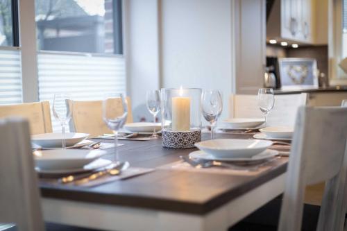 uma mesa com copos e pratos e uma vela sobre ela em Alte Waescherei _9461_ em List