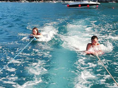 a man and a woman are in the water at Apartment "I Love Njivice" in Herceg-Novi